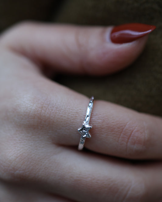 Detailed view of a silver Polaris star ring worn on a finger, highlighting its handcrafted hammered finish.
