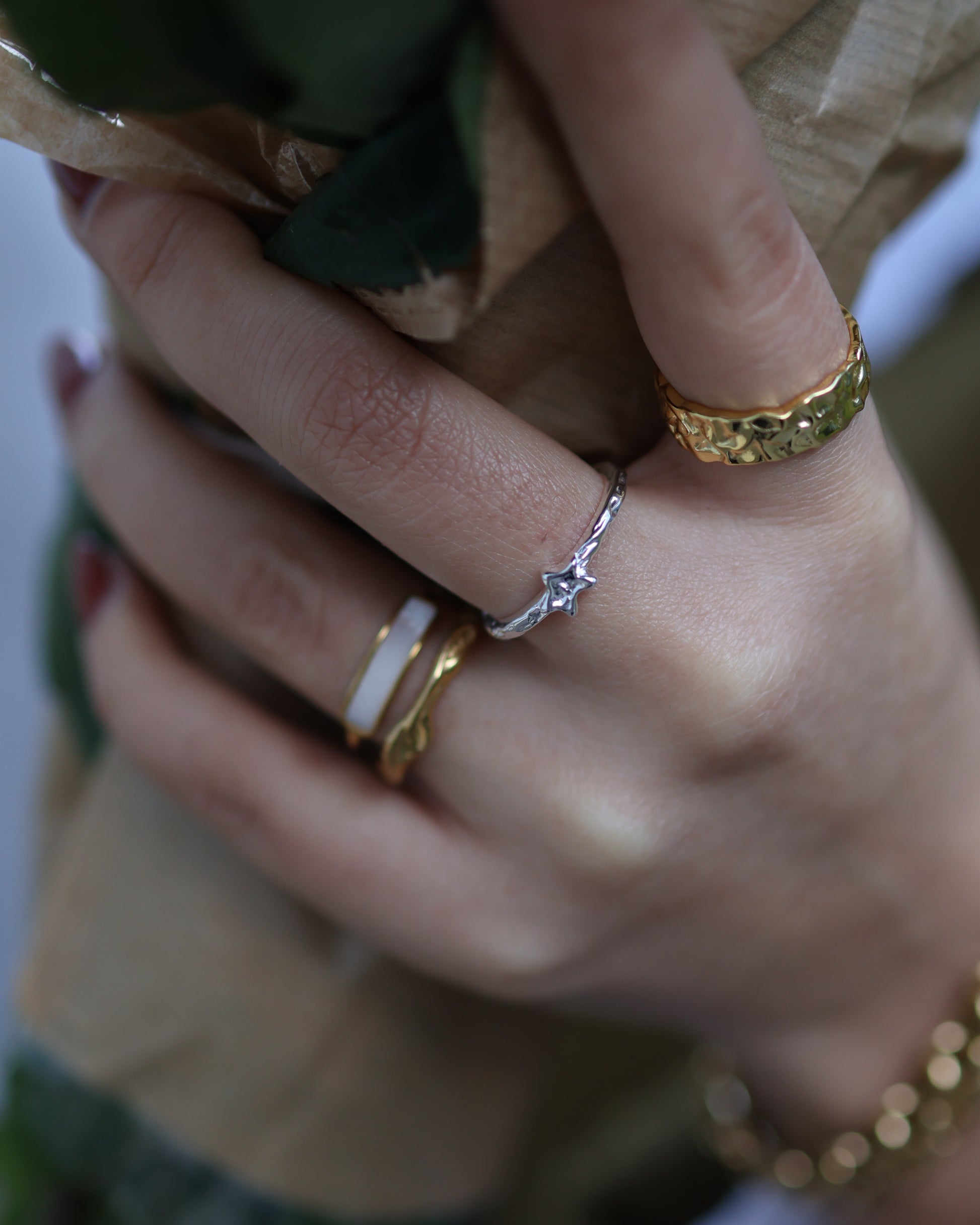 Ring stacking inspiration featuring the silver Polaris ring and gold textured bands on a woman's hand.